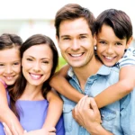 a portrait of a family of 4 smiling and posing.