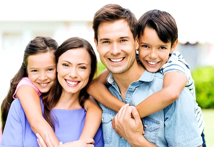a portrait of a family of 4 smiling and posing.