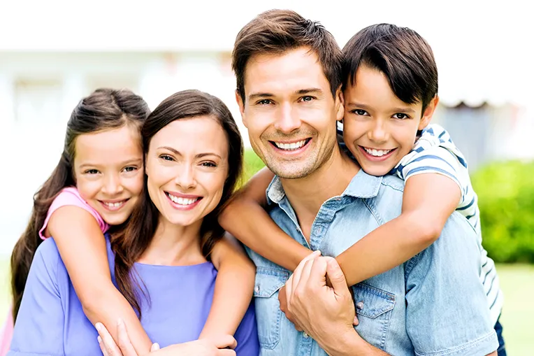 a portrait of a family of 4 smiling and posing.