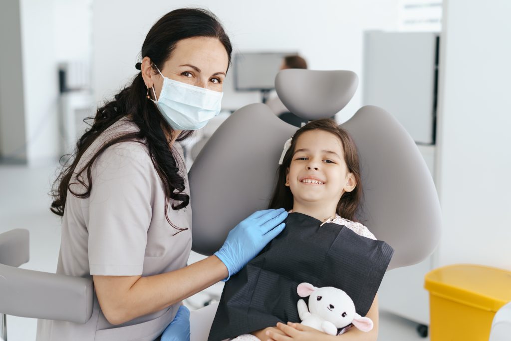 A team member at Bentley Dental and a child patient posing during dental checkup