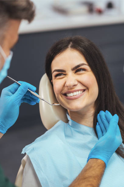 Dentist discussing with smiling female patient