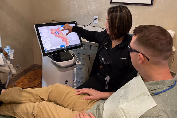 Nurse demonstrating 3D model of a patients lower jaw to the patient.